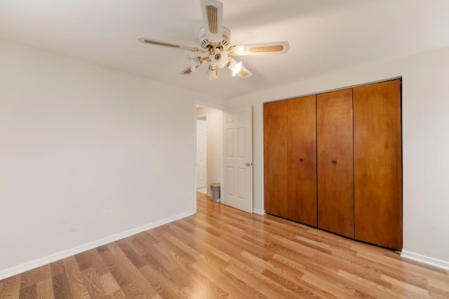 unfurnished bedroom with light wood-type flooring, baseboards, a closet, and ceiling fan