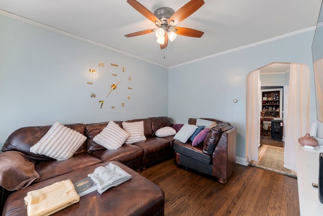 living area featuring ceiling fan, arched walkways, wood finished floors, and crown molding