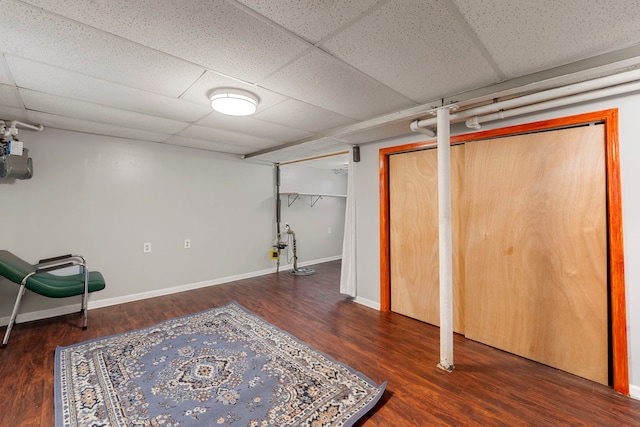 finished below grade area with wood finished floors, baseboards, and a paneled ceiling