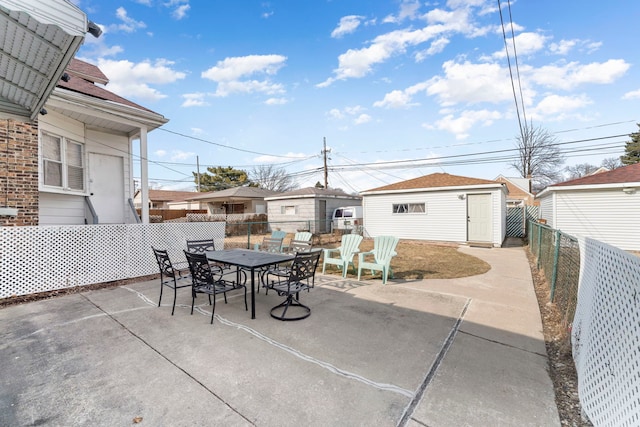 view of patio featuring a fenced backyard, an outdoor structure, and outdoor dining space