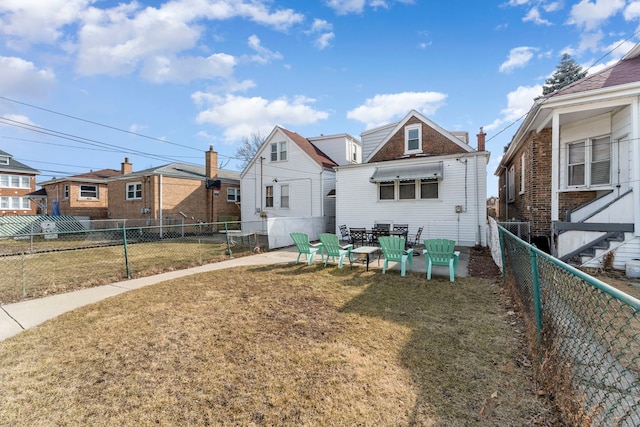 back of house with a yard and a fenced backyard