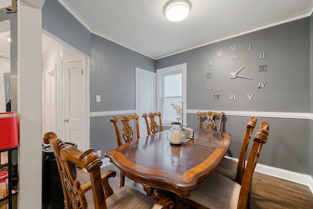 dining room featuring baseboards, wood finished floors, and ornamental molding