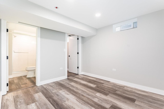 below grade area with baseboards and wood finished floors