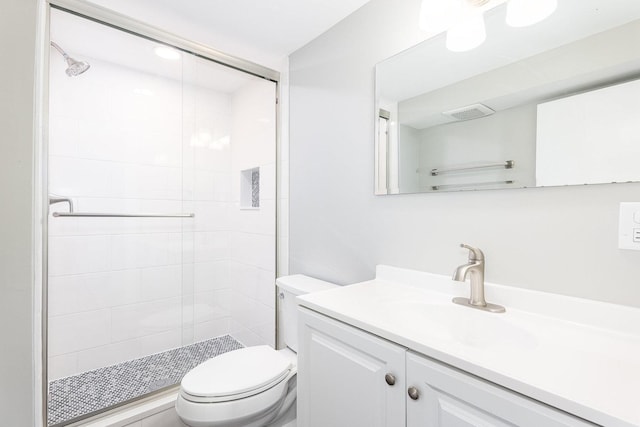 bathroom featuring visible vents, a stall shower, toilet, and vanity