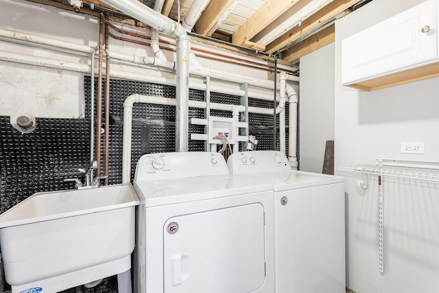 laundry area featuring cabinet space, washing machine and dryer, and a sink