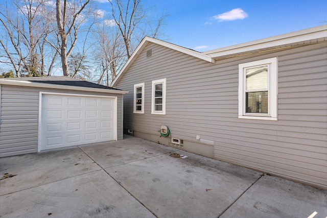 view of side of home featuring an outbuilding, driveway, and a detached garage