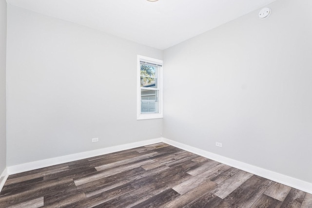 empty room featuring dark wood-style floors and baseboards