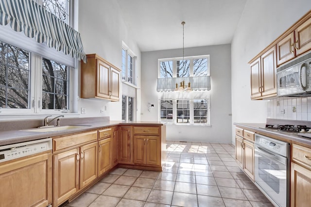 kitchen featuring stainless steel gas cooktop, a sink, decorative backsplash, oven, and dishwasher