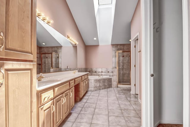 bathroom with double vanity, a sink, a shower stall, a garden tub, and tile patterned floors