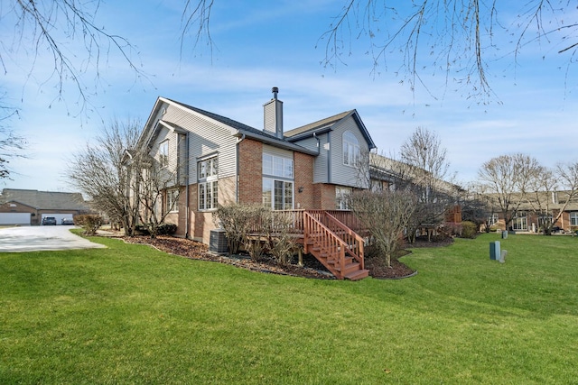 view of side of property featuring a yard, brick siding, central AC, and a chimney