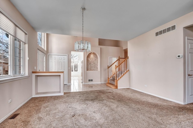 foyer with visible vents, carpet, and stairway