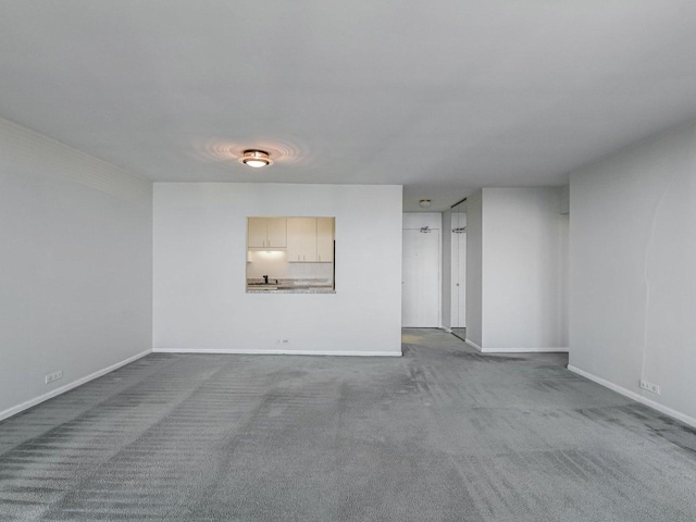 empty room with baseboards and dark carpet