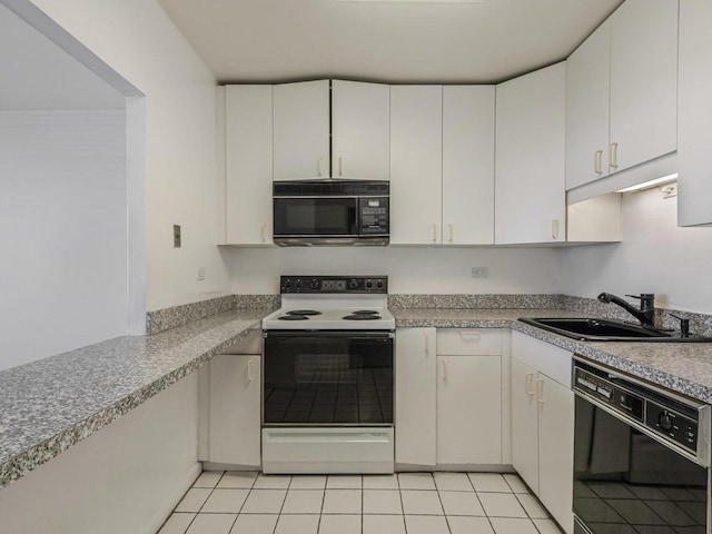 kitchen with black appliances, white cabinets, light tile patterned flooring, and a sink