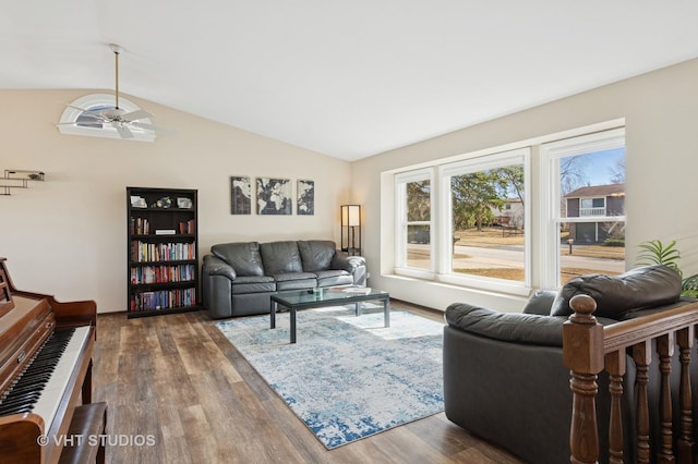 living area featuring ceiling fan, wood finished floors, and vaulted ceiling