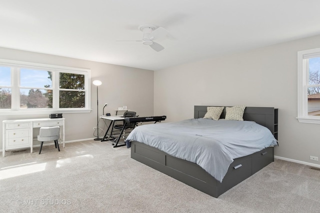 bedroom with a ceiling fan, light colored carpet, and baseboards