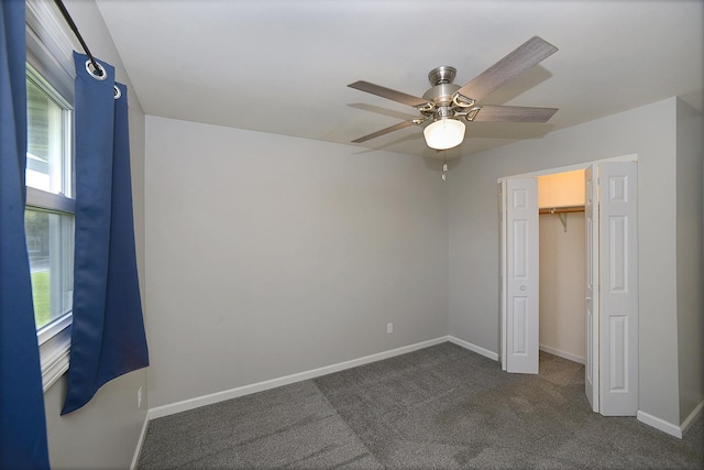 unfurnished bedroom with a closet, ceiling fan, baseboards, and dark colored carpet