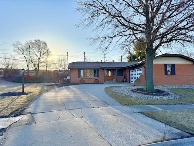 view of front of home with brick siding, driveway, and a garage