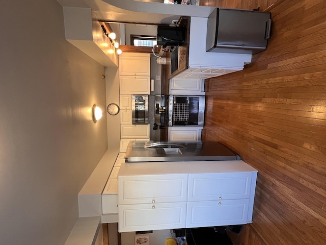 kitchen with wood walls and white cabinets