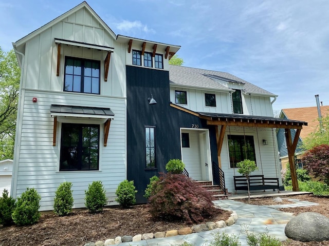 modern inspired farmhouse with a shingled roof, metal roof, a standing seam roof, covered porch, and board and batten siding