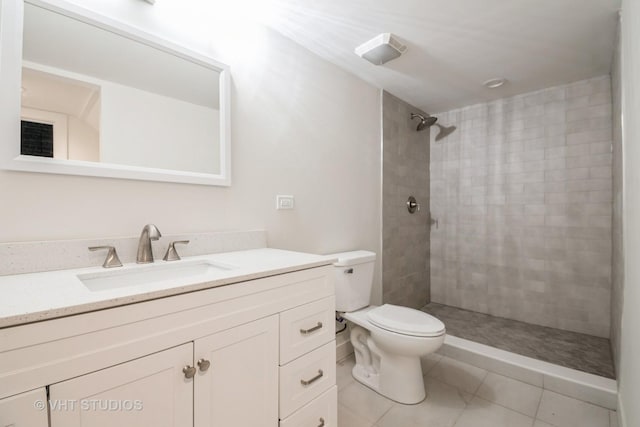 bathroom with vanity, toilet, and tiled shower