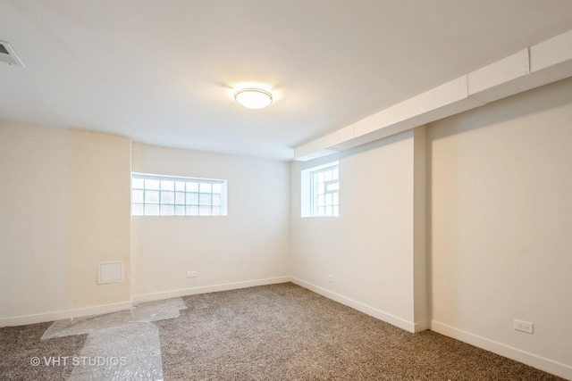 below grade area featuring carpet flooring, visible vents, and baseboards