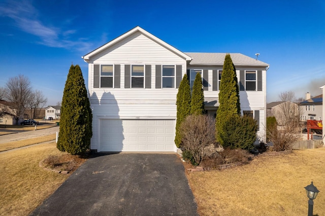 view of front of property with a front lawn, a garage, and driveway