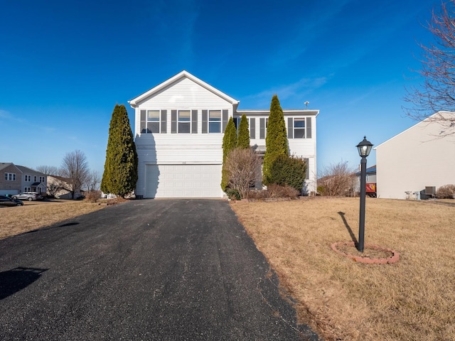 view of front of home featuring aphalt driveway, a garage, and a front lawn