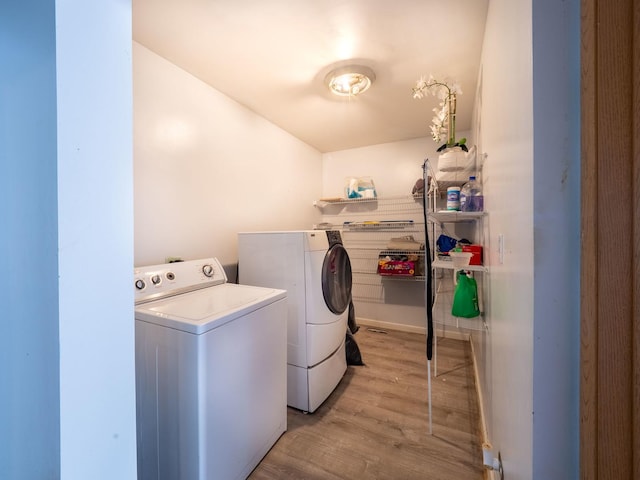 laundry area featuring washer and clothes dryer, laundry area, and light wood-type flooring