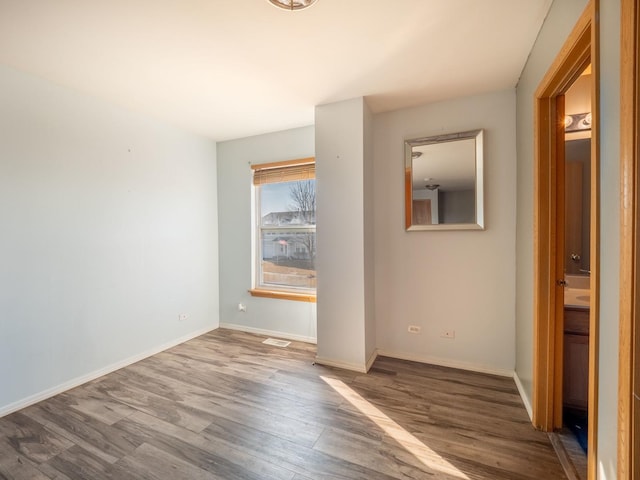 empty room featuring wood finished floors and baseboards