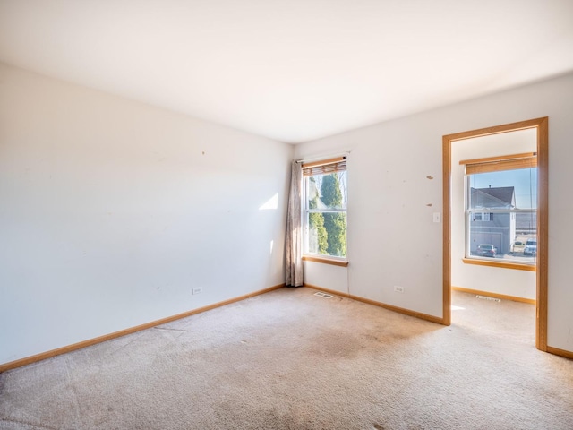 spare room featuring visible vents, baseboards, and carpet floors