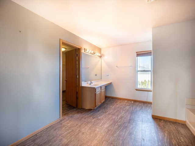 full bath with visible vents, baseboards, vanity, and a bathing tub