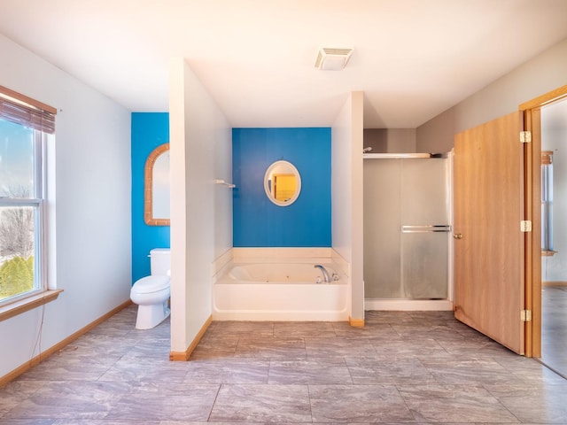 bathroom with a wealth of natural light, baseboards, a garden tub, and a shower stall