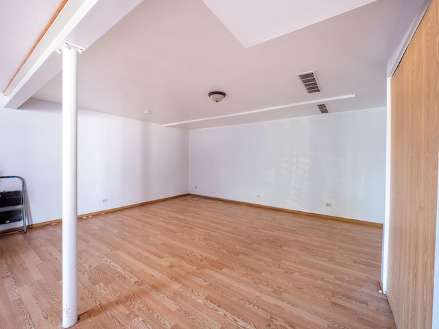 interior space with light wood-type flooring, visible vents, and baseboards