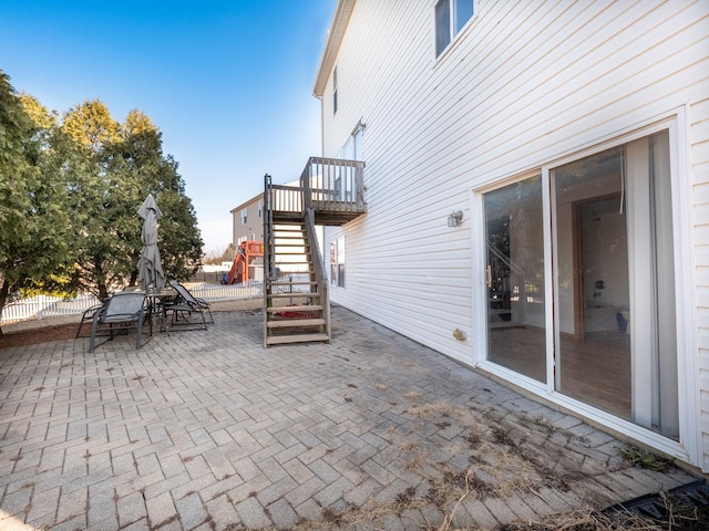 view of patio with stairs and fence