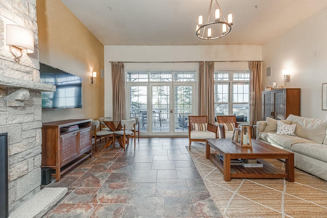 living room featuring an inviting chandelier, a healthy amount of sunlight, and stone finish flooring