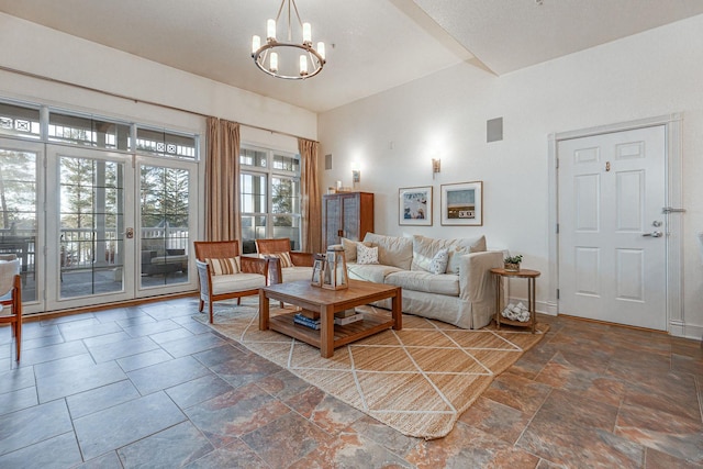 living room with a chandelier, visible vents, stone finish flooring, and baseboards