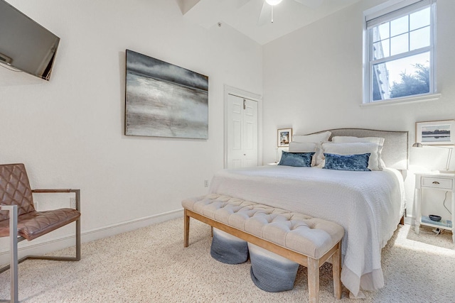 carpeted bedroom featuring a closet, baseboards, and ceiling fan