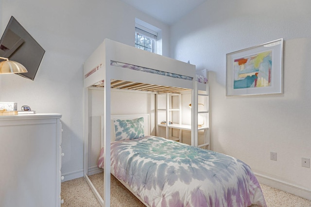 bedroom featuring speckled floor and baseboards