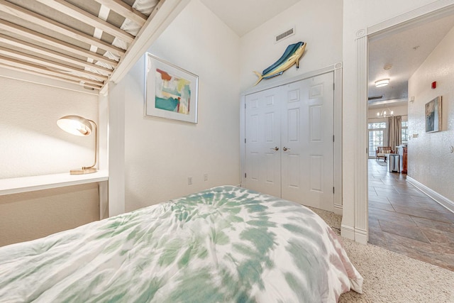 bedroom featuring a closet, baseboards, visible vents, and carpet floors