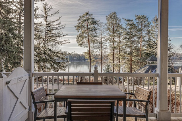 deck featuring outdoor dining area and a water view