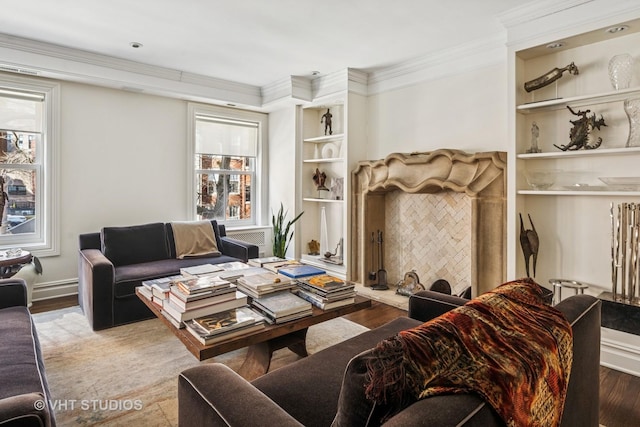 living room featuring built in shelves, wood finished floors, baseboards, and ornamental molding