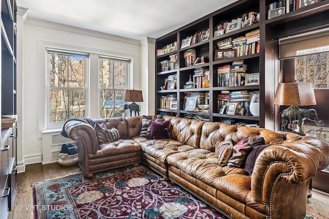 living room featuring baseboards, wood finished floors, and crown molding