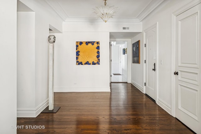 hallway with an inviting chandelier, wood finished floors, baseboards, and ornamental molding