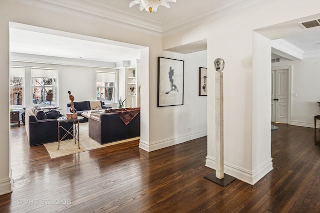 interior space with dark wood-type flooring, crown molding, visible vents, and baseboards