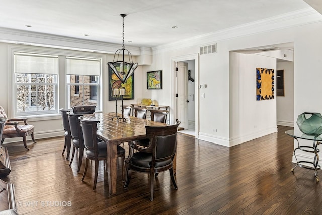 dining room featuring dark wood finished floors, baseboards, visible vents, and ornamental molding