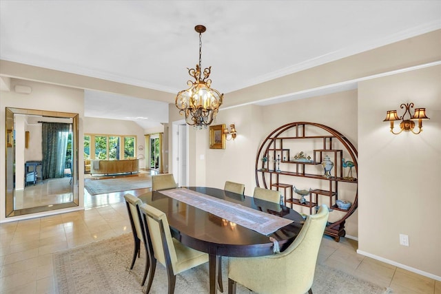 dining space featuring a chandelier, baseboards, light tile patterned flooring, and crown molding