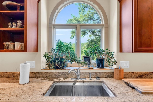 interior space with a sink and light stone counters