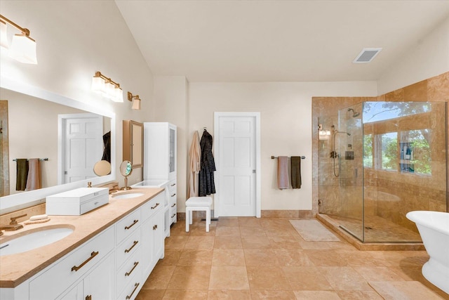 full bathroom with a sink, lofted ceiling, double vanity, and a shower stall