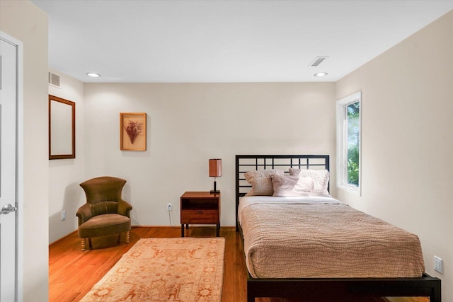 bedroom with recessed lighting, wood finished floors, and visible vents