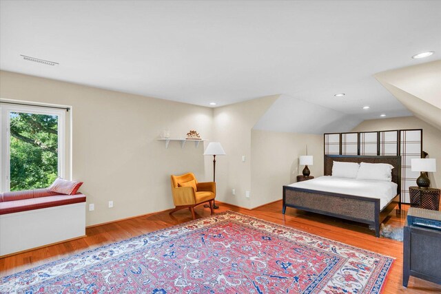 bedroom with visible vents, recessed lighting, lofted ceiling, and wood finished floors